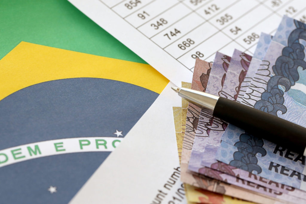 Pen With Brazilian Money Bills On Blank Of Lottery Game. Concept Of Luck And Gambling In Brazil Focus Contabilidade - A2 Consultores | Consultoria em São Paulo